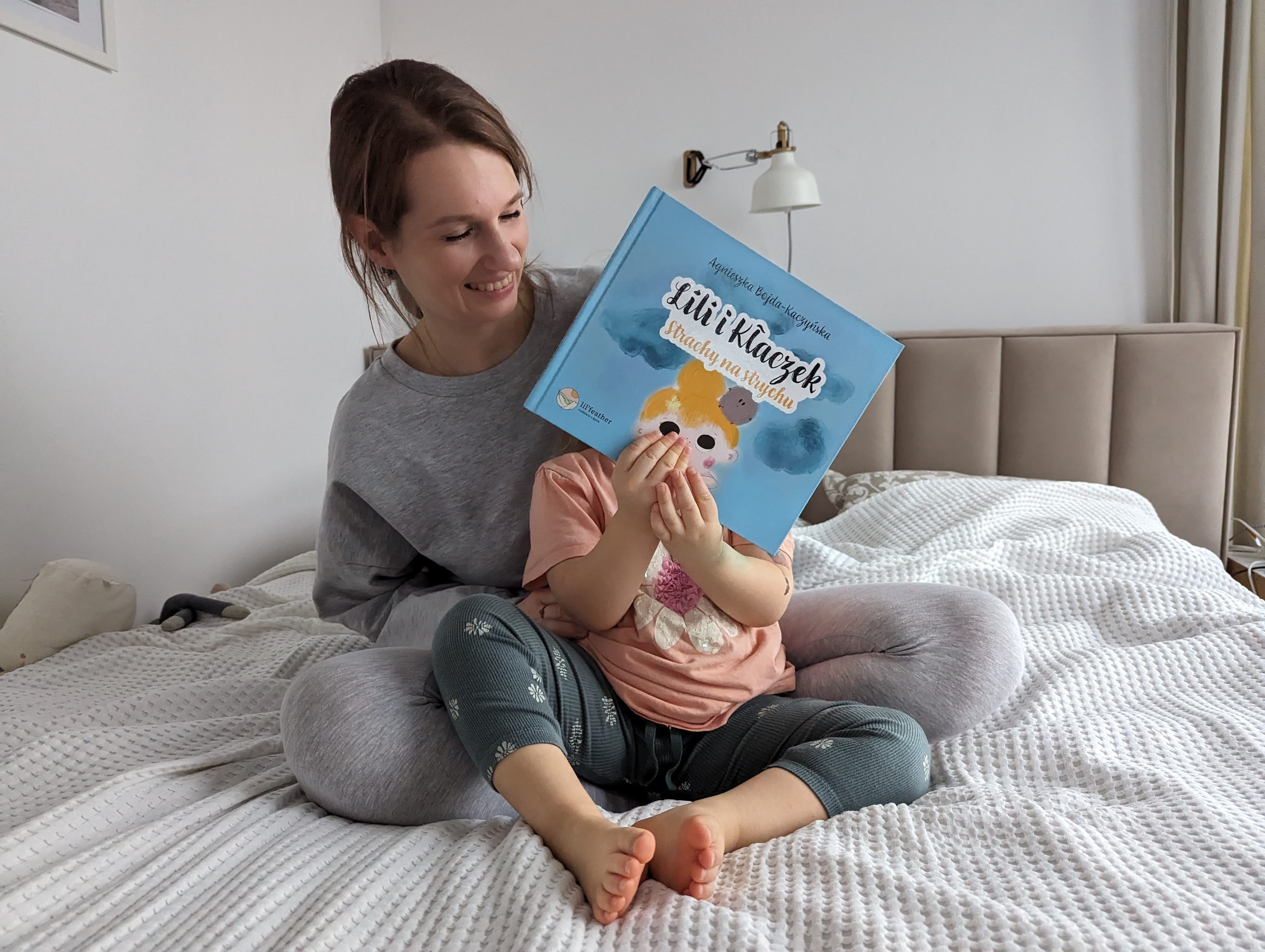 Mama czyta dziecku Lili i Kłaczka w łóżku